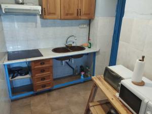 una pequeña cocina con fregadero y microondas en La Casa los Trancos, muy cerca de Cazorla, en Peal de Becerro
