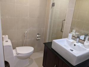bagno con servizi igienici bianchi e lavandino di The Sands beach apartment a Nai Harn Beach
