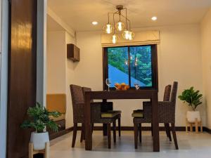 una sala da pranzo con tavolo, sedie e finestra di The Sands beach apartment a Nai Harn Beach