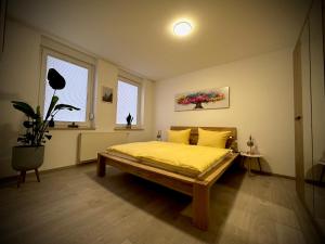 a bedroom with a bed with yellow sheets and a window at Ferienwohnung Amelie in Thale