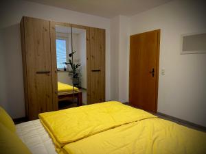 a bedroom with a bed with a yellow blanket at Ferienwohnung Amelie in Thale