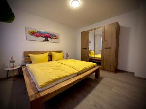 a bedroom with a bed with yellow sheets and a mirror at Ferienwohnung Amelie in Thale