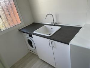 a kitchen with a sink and a washing machine at Ameyal Casa PIO XII in Sanlúcar de Barrameda