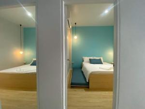um quarto com 2 camas e uma parede azul em FEEL LIKE HOME BETONG ฟีลไลค์โฮม เบตง em Betong