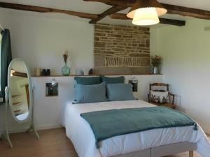 1 dormitorio con cama y pared de ladrillo en Le Manoir de la Beslière - Gîte et Chambres d'hôtes, en Folligny