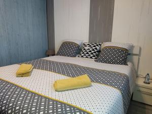 Una cama con dos toallas amarillas. en A la bonne étape, en Sassenay