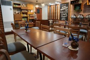 馬尼拉的住宿－奎松市馬勒卡費薩爾酒店，一间带木桌和椅子以及黑板的餐厅