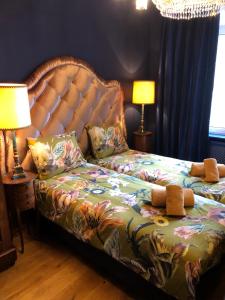 a bedroom with a bed with a headboard and two lamps at Sint Andries Suites in Antwerp