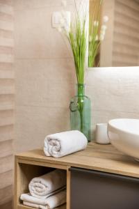 baño con lavabo y jarrón con toallas en Apartment Dana, en Rijeka 16 fotos más