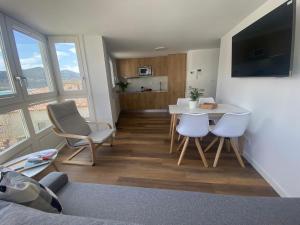 a living room with a table and chairs and a kitchen at APARTAMENTOS ARATUSTE - News a estrenar in Mundaka