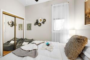 een slaapkamer met een groot wit bed en handdoeken bij Cozy 1BR Unit in Prime Location - Perfect for Solo Travelers or Couples! in Hounslow