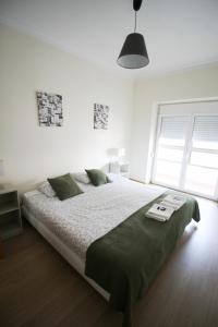 sypialnia z dużym łóżkiem w białym pokoju w obiekcie Oriente DNA Studios V w Lizbonie