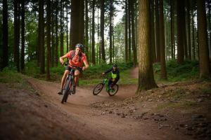 two people riding bikes on a dirt trail in the woods at Vakantiewoning Duitsland in Freisen
