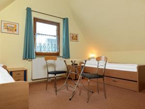 1 Schlafzimmer mit einem Bett, einem Tisch und 2 Stühlen in der Unterkunft Reethus Blinkfüer in Timmendorf