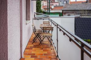 zwei Stühle auf dem Balkon eines Gebäudes in der Unterkunft Zentrales 7Seas Apartment Kaiserslautern - Balkon l 4 Pers l Self Check-in in Kaiserslautern