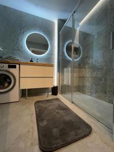 a bathroom with a shower and a washing machine at Harry’s Apartment/centrum/parking in Wrocław