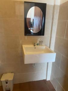 La salle de bains est pourvue d'un lavabo blanc et d'un miroir. dans l'établissement D'TRANSIT, à Nusa Penida