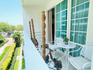 a balcony with a table and chairs on a building at Summer Huahin311, 150m from beach. Near Cicada and Tamarind. in Hua Hin