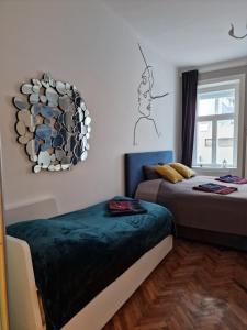 sypialnia z 2 łóżkami i lustrem na ścianie w obiekcie 4 seasons apartment w Wiedniu