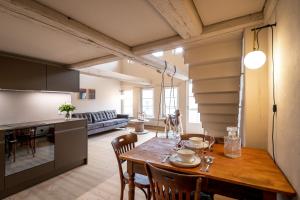 una cucina e un soggiorno con tavolo e sedie in legno di JACOB 1808. fine historic town apartments a Bischofszell Altre 36 foto