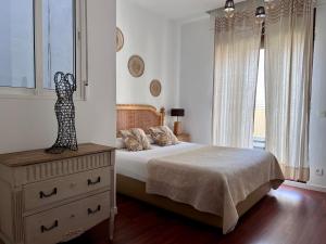 a bedroom with a bed and a dresser and a window at Valencia Luxury - Boutique Market in Valencia