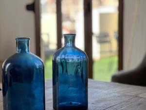 バレンシアにあるValencia Luxury - Boutique Marketの木製テーブルに座る青いガラスの花瓶2本