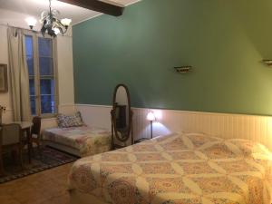 a bedroom with a bed and a chair and a mirror at Mia Casa in Arles