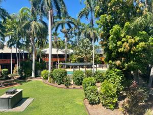 a park with palm trees and a swimming pool at Broome Time Resort in Broome
