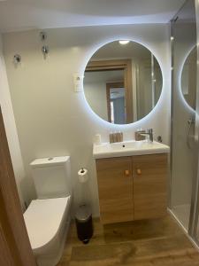 a bathroom with a toilet and a sink and a mirror at APARTAMENTOS ARATUSTE - News a estrenar in Mundaka