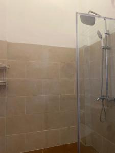 La salle de bains est pourvue d'une douche avec une porte en verre. dans l'établissement D'TRANSIT, à Nusa Penida