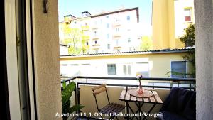 維爾茨堡的住宿－Moderne Altbauapartments, Nahe Stadtzentrum & Weinberge，一个带桌椅的阳台和一座建筑