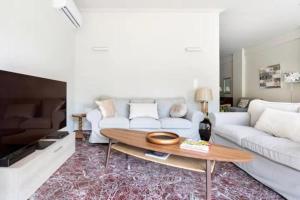 un soggiorno con divano bianco e tavolo di Flisvos Marina refurbished apartment ad Atene