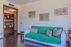 a living room with a green couch in a room at Ca' Maria Lavanda by Wonderful Italy in Bellagio