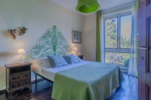 a bedroom with a bed with blue pillows and a window at Ca' Maria Lavanda by Wonderful Italy in Bellagio
