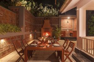 a dining room with a table and a fireplace at The Haven Grandeur - Where Nature meets Luxury - Coorg in Madikeri