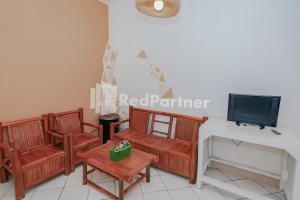 a living room with two chairs and a tv at Villa Puncak Agape near Cipanas Mitra RedDoorz in Cianjur