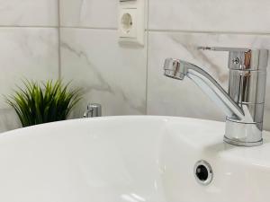 a white bathroom sink with a faucet on it at Church Hill Apartment in Daugavpils +19 photos