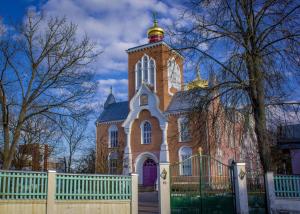 a large church with a fence in front of it at Church Hill Apartment in Daugavpils