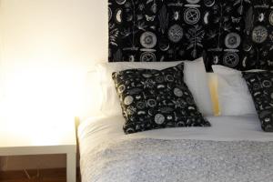 Una cama con almohadas blancas y negras. en Casa Olivi, en Civate