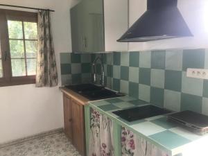 una cocina con encimeras de azulejos verdes y blancos y fregadero en Studio mitoyen / 2 personnes en Hyères