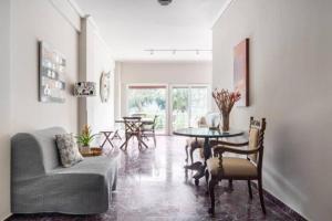 Flisvos Marina refurbished apartment في أثينا: غرفة معيشة مع أريكة وطاولة