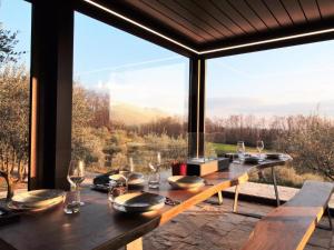 Chalet Dolce Colle في Volpago del Montello: غرفة طعام مع طاولة ونافذة كبيرة