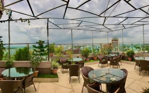 een restaurant met tafels en stoelen op een dak bij Hotel Shuktara Dhaka in Dhaka