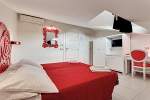 a bedroom with a bed with a red blanket at Hotel Le Cinéma in Gatteo a Mare