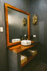 a bathroom with a mirror and two sinks and masks at Casa De Loren in General Luna