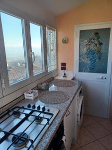 a kitchen with a stove top and two windows at Casa Belvedere in Citerna