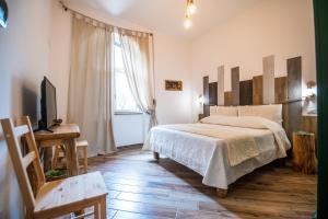 Dormitorio con cama, escritorio y TV en Panacea Country Honey House en Santa Maria di Castellabate