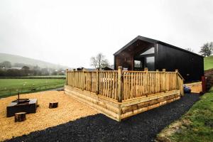 a small house with a wooden fence in a field at Fawns Rest in Nantmel