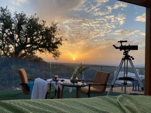 a table with a camera and a camera tripod at Eco-Lodge en la Reserva Privada Campanarios de Azaba - Proyecto de Conservación in Espeja
