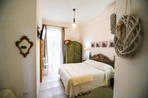 Habitación blanca con cama y ventana en Panacea Country Honey House en Santa Maria di Castellabate